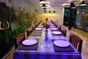 a long table with chairs and plates and flowers on it at Chalets Resort Masinagudi in Ooty