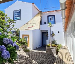 uma casa branca com flores à frente em Quinta da Meia Eira em Castelo Branco