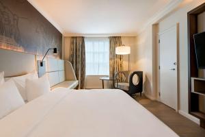 een hotelkamer met een groot wit bed en een raam bij Radisson Blu Hotel, Antwerp City Centre in Antwerpen