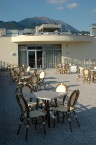 um grupo de mesas e cadeiras em frente a um edifício em Hotel Krek Superior em Lesce