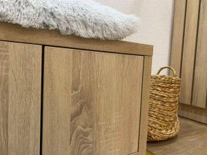 ein Holzschrank mit einem Korb darüber in der Unterkunft Alexandrea Apartments in Pale