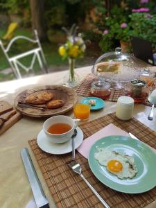 Bed and Breakfast Jardin de Marie في آكس أون بروفانس: طاولة مع طبق من البيض وكوب من الشاي