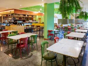 a restaurant with tables and chairs in a room at Hotel Nacional Inn Curitiba Santa Felicidade in Curitiba