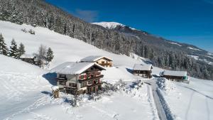 um edifício coberto de neve numa montanha de neve em Jugend- und Familienhotel Venedigerhof em Neukirchen am Großvenediger