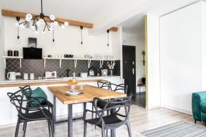 una cucina e una sala da pranzo con tavolo e sedie in legno di Apartament Onyks a Zakopane