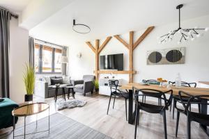 una sala da pranzo e un soggiorno con tavolo e sedie. di Apartament Onyks a Zakopane