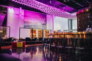 - un bar avec des chaises et un éclairage violet dans la chambre dans l'établissement Quality Hotel Globe, à Stockholm