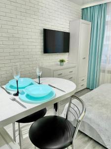 a room with a table with two chairs and a tv at Tiffany Apartment in Irpin'