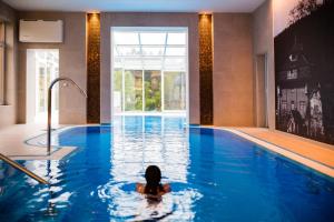 een persoon die zwemt in een zwembad bij Luxury Spa & Wellness Vila Valaška in Luhačovice