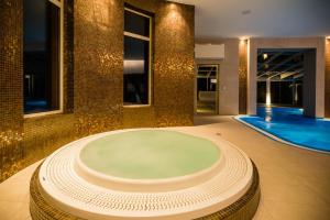 een groot bad in een kamer met een zwembad bij Luxury Spa & Wellness Vila Valaška in Luhačovice