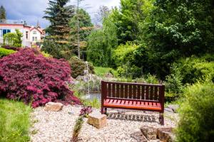 een bank in het midden van een tuin bij Luxury Spa & Wellness Vila Valaška in Luhačovice