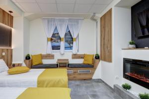 1 Schlafzimmer mit 2 Betten und einem Kamin in der Unterkunft Riverside Inn - dunaparti szuterén in Győr