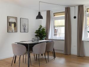 a dining room with a black table and chairs at limehome Baden-Baden Bäderstraße in Baden-Baden