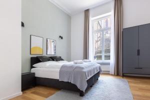 a white bedroom with a bed and a window at limehome Baden-Baden Bäderstraße in Baden-Baden