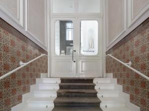 a stairway with a white door and a stair case at limehome Baden-Baden Bäderstraße in Baden-Baden