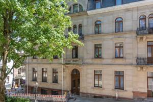 a large building with a tree in front of it at limehome Baden-Baden Bäderstraße in Baden-Baden