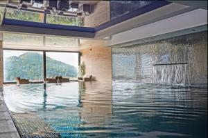 ein großer Pool mit einer großen Glaswand in der Unterkunft Apart & Spa Zoned in Kopaonik