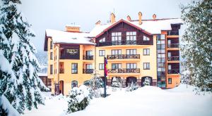 a large yellow building with snow on the ground at СПА-Готель "RESPECT" in Skhidnitsa