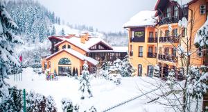 a building with snow on the ground in front of it at СПА-Готель "RESPECT" in Skhidnitsa