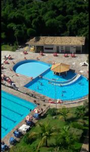 an overhead view of a large swimming pool at ÁGUAS TERMAIS NATURAIS nas PISCINAS com ÁGUAS QUENTES 24 HORAS acesso GRÁTIS aos PARQUES AQUÁTICOS dos RESORTS GOLDEN DOLPHIN GRAND HOTEL do SUPREME e do EXPRESS os melhores HOTÉIS RESORTS com PARQUE AQUÁTICO em CALDAS NOVAS Garanta JÁ PROMOÇÃO QUALIDADE in Caldas Novas