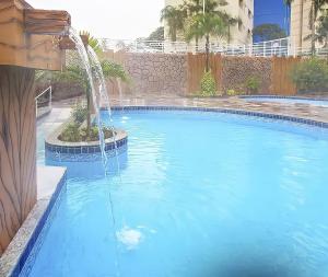 a large swimming pool with a water fountain at ÁGUAS TERMAIS NATURAIS nas PISCINAS com ÁGUAS QUENTES 24 HORAS acesso GRÁTIS aos PARQUES AQUÁTICOS dos RESORTS GOLDEN DOLPHIN GRAND HOTEL do SUPREME e do EXPRESS os melhores HOTÉIS RESORTS com PARQUE AQUÁTICO em CALDAS NOVAS Garanta JÁ PROMOÇÃO QUALIDADE in Caldas Novas