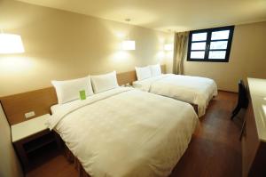 Una cama o camas en una habitación de Kindness Hotel - Kaohsiung Main Station