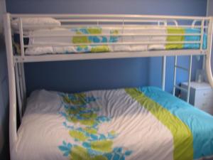 a white bunk bed with a colorful blanket on it at Horace Street 8 in Shoal Bay