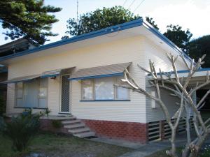 a white house with a blue roof at Horace Street 8 in Shoal Bay