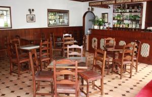 un ristorante con tavoli e sedie in legno e un bar di Hotel Dona Leonor a Caldas da Rainha