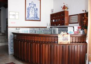 un bar in legno in un ristorante con una statua sul muro di Hotel Dona Leonor a Caldas da Rainha