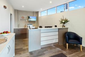 an office with a reception desk and a chair at Fawkner Executive Suites & Serviced Apartments in Melbourne