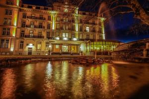 een gebouw voor een rivier 's nachts bij Parkhotel du Sauvage in Meiringen