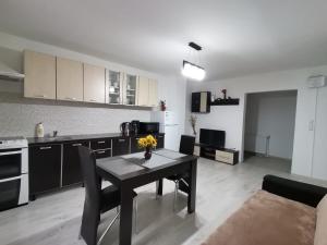 cocina y comedor con mesa en una habitación en Mario Apartament regim hotelier, en Reşiţa