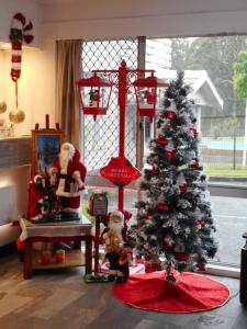 uma sala de estar com uma árvore de Natal e cláusulas do Pai Natal em Molly Morgan Motor Inn em Maitland