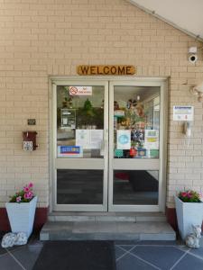 um sinal de boas-vindas acima da porta de uma loja em Molly Morgan Motor Inn em Maitland