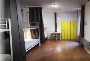 a room with two bunk beds and a yellow door at Le Coffice Auberge de Jeunesse in Paris