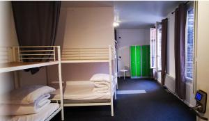 a room with two bunk beds and a green door at Le Coffice Auberge de Jeunesse in Paris