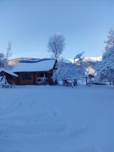 eine Blockhütte mit Schnee auf dem Dach in der Unterkunft Cottage Лісовий in Bukovets