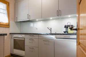 a kitchen with white cabinets and a sink at Chalet Sunnegga in Fiesch