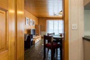 a dining room with a table and a living room at Chalet Sunnegga in Fiesch