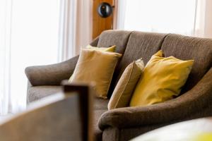 a couch with yellow pillows sitting in a living room at Chalet Sunnegga in Fiesch