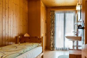 a bedroom with a bed and a sink and a window at Chalet Sunnegga in Fiesch