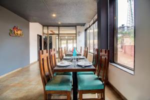 une salle à manger avec une grande table et des chaises dans l'établissement Mountain Breeze Resort, Mahabaleshwar, à Mahabaleshwar