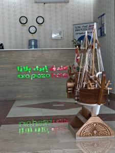 a model of a pirate ship in a room with clocks at Ibra Plaza Hotel in Ibrā