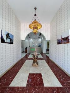 a large room with a chandelier and a hallway at Ibra Plaza Hotel in Ibrā