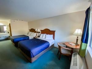 um quarto de hotel com duas camas e uma mesa em Green Gables Inn em Branson