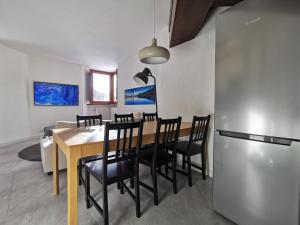 a dining room with a table and chairs and a refrigerator at Aura Apartment - Ski In & Ski Out - Cerviniaholidays-com in Breuil-Cervinia