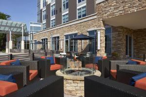 un patio avec des chaises et un foyer extérieur en face d'un bâtiment dans l'établissement Hyatt Place Evansville, à Evansville