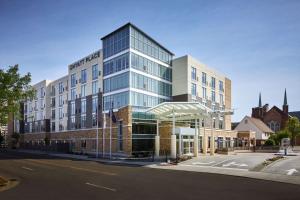 un grand bâtiment en verre au coin d'une rue dans l'établissement Hyatt Place Evansville, à Evansville