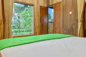 a bedroom with a large bed and a window at Lesehan Cahaya Tetebatu Inn Syariah at Desa Wisata in Tetebatu